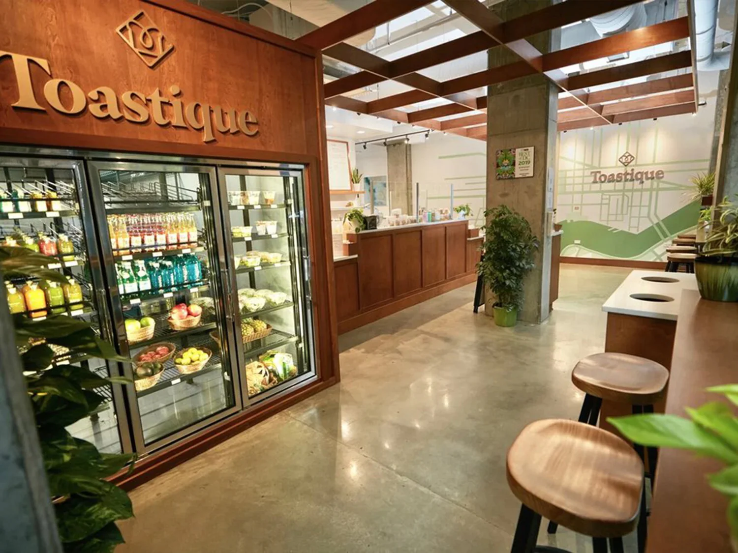 Inside a Toastique café with a cold-pressed juice display fridge and modern seating, showing the juice bar franchise model built for all-day traffic.