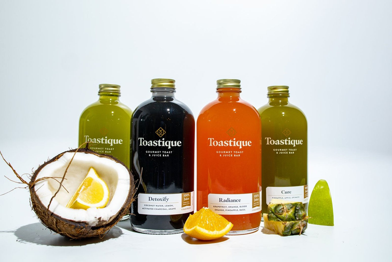 A lineup of Toastique cold-pressed juices — Detoxify, Radiance, Cure, and Balance, made fresh daily at Toastique, Arlington, VA.