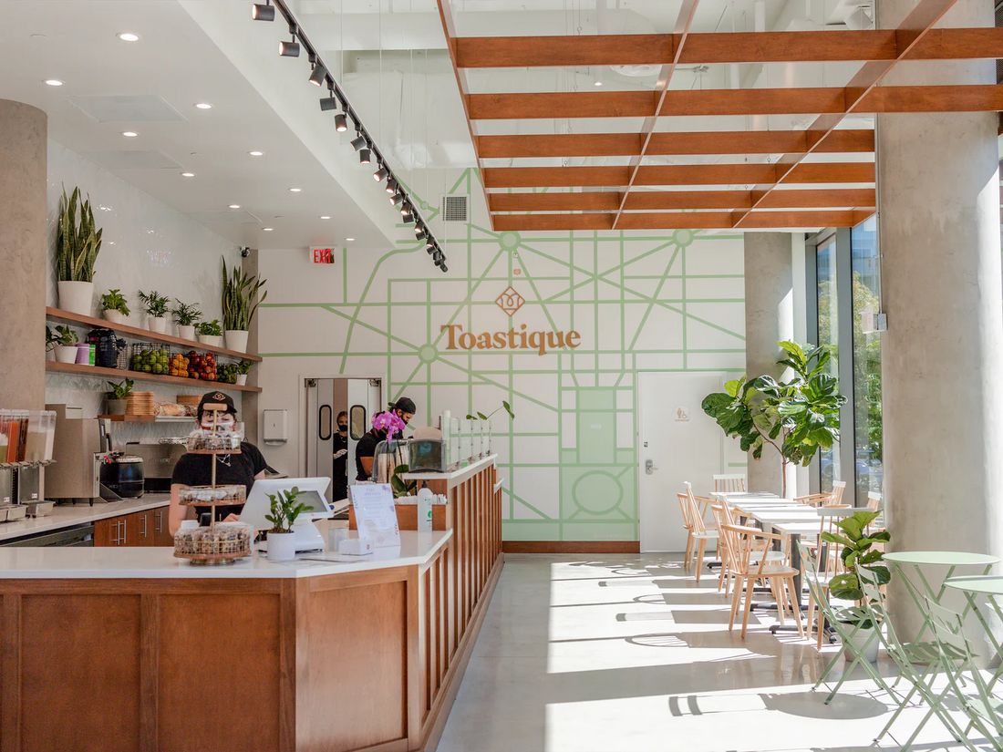 Bright interior of Toastique Dupont Circle café in Washington D.C., featuring natural light, wooden details, and a modern espresso bar designed for quick, fresh brunch service.