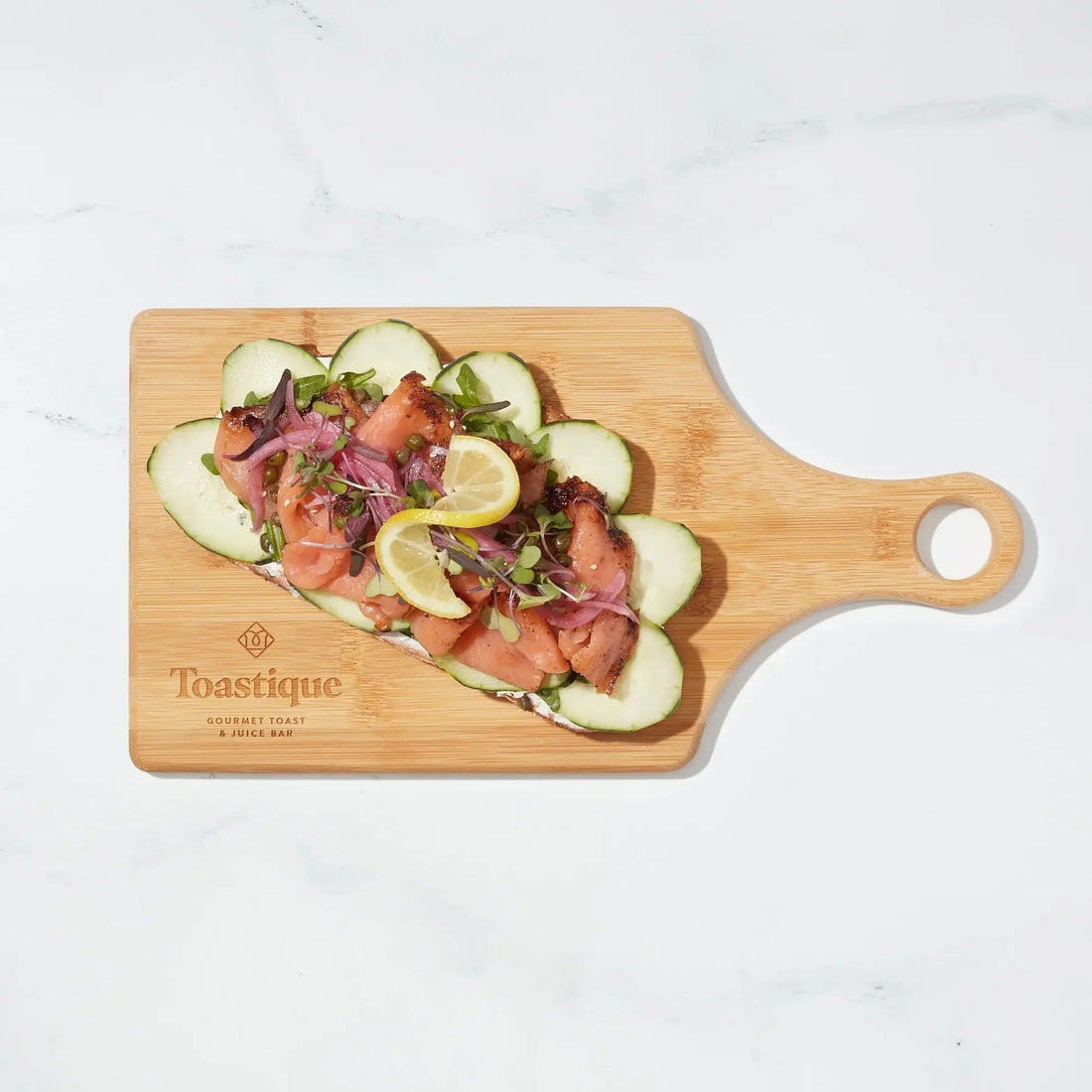Toastique Smoked Salmon Toast, a high-protein breakfast without eggs, served on a branded Toastique wooden board