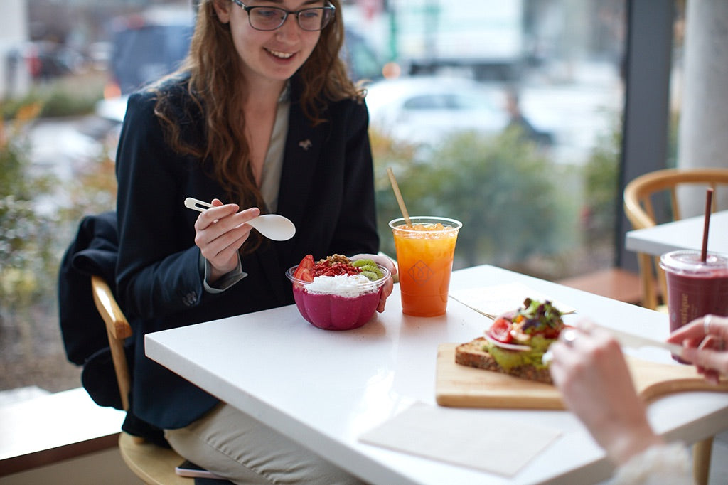 Guest enjoying a smoothie bowl, fresh juice, and gourmet toast inside a Toastique breakfast franchise, highlighting the best breakfast franchise opportunities.