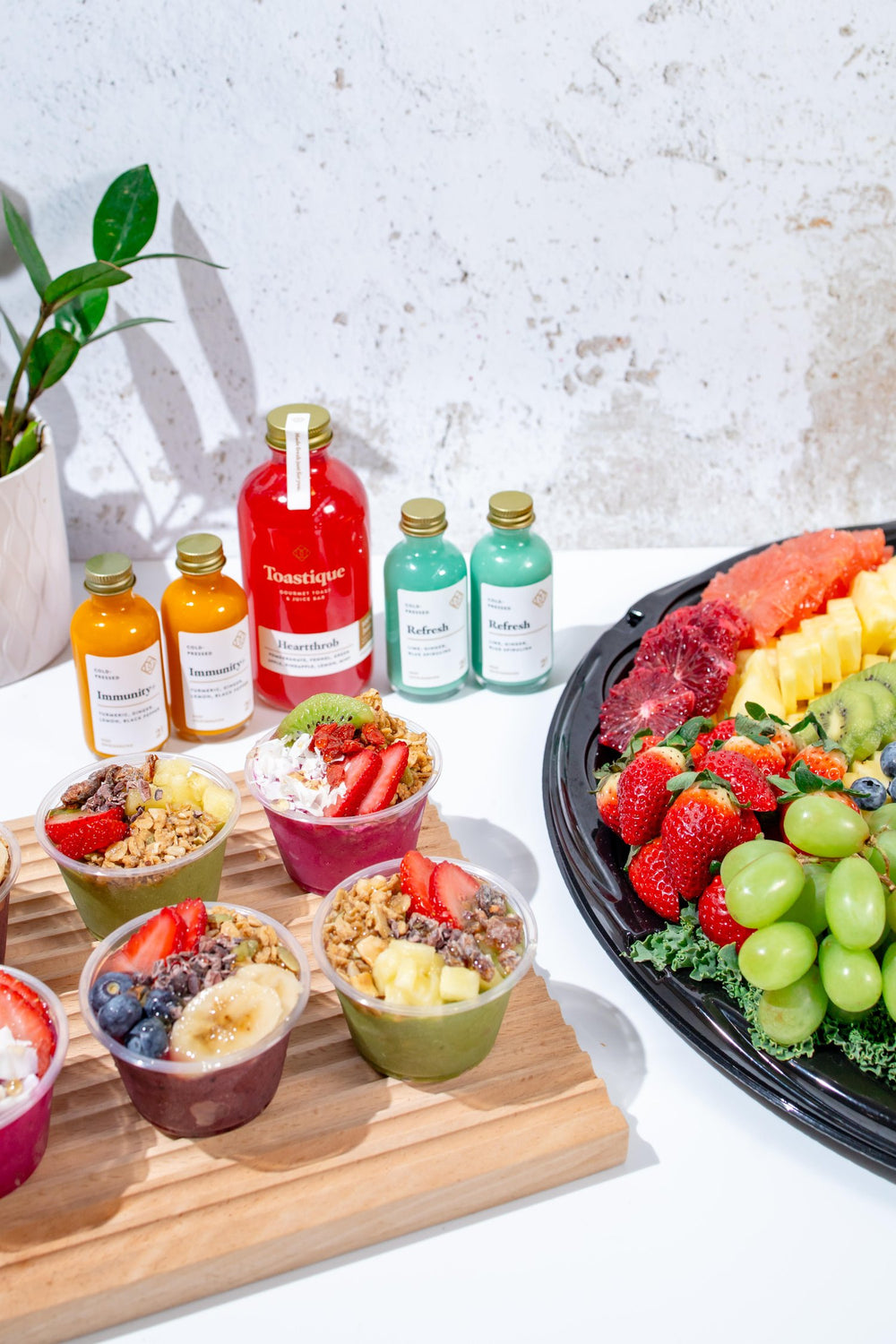 Toastique cold-pressed juices, wellness shots, smoothie bowl cups and fruit platter