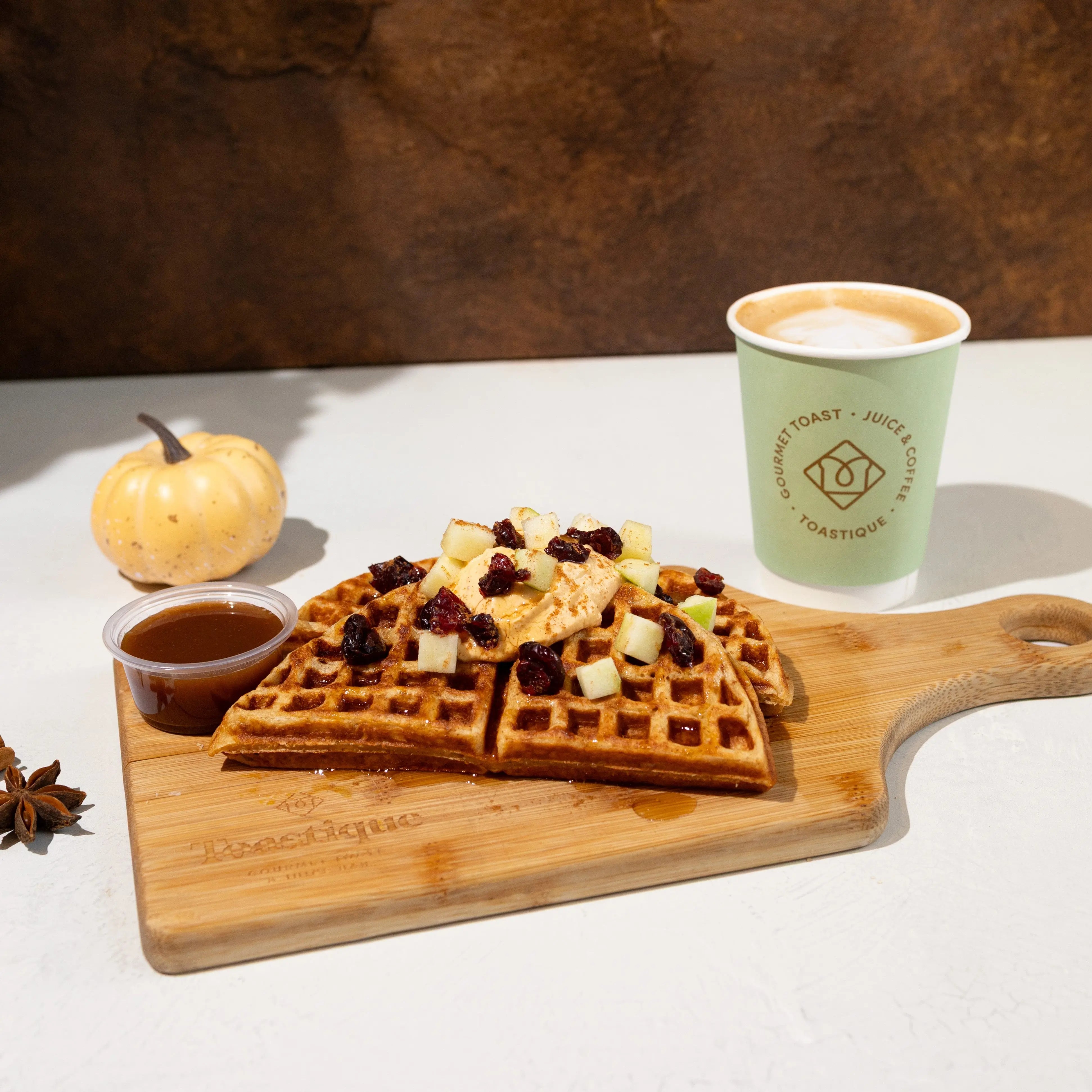 Housemade protein waffle, with pumpkin cheesecake filling, granny smith apples, dried cranberries, pumpkin syrup (served on the side).